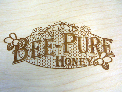 An example of laser engraving for wood with a wooden item featuring a personalized logo for Bee-Pure Honey.