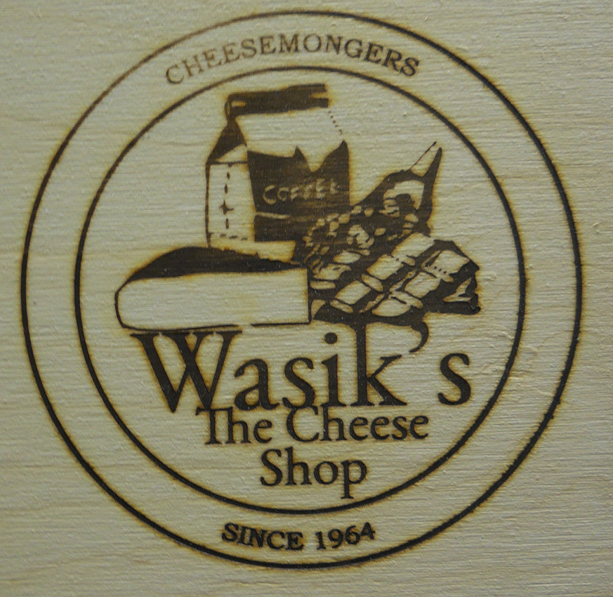 An example of wood burning for private labeling on a wood product with a logo for Wasik’s The Cheese Shop.